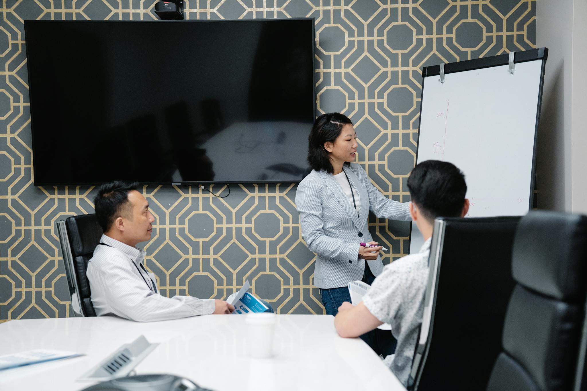 A professional conducting a presentation in a modern office space with colleagues engaged.