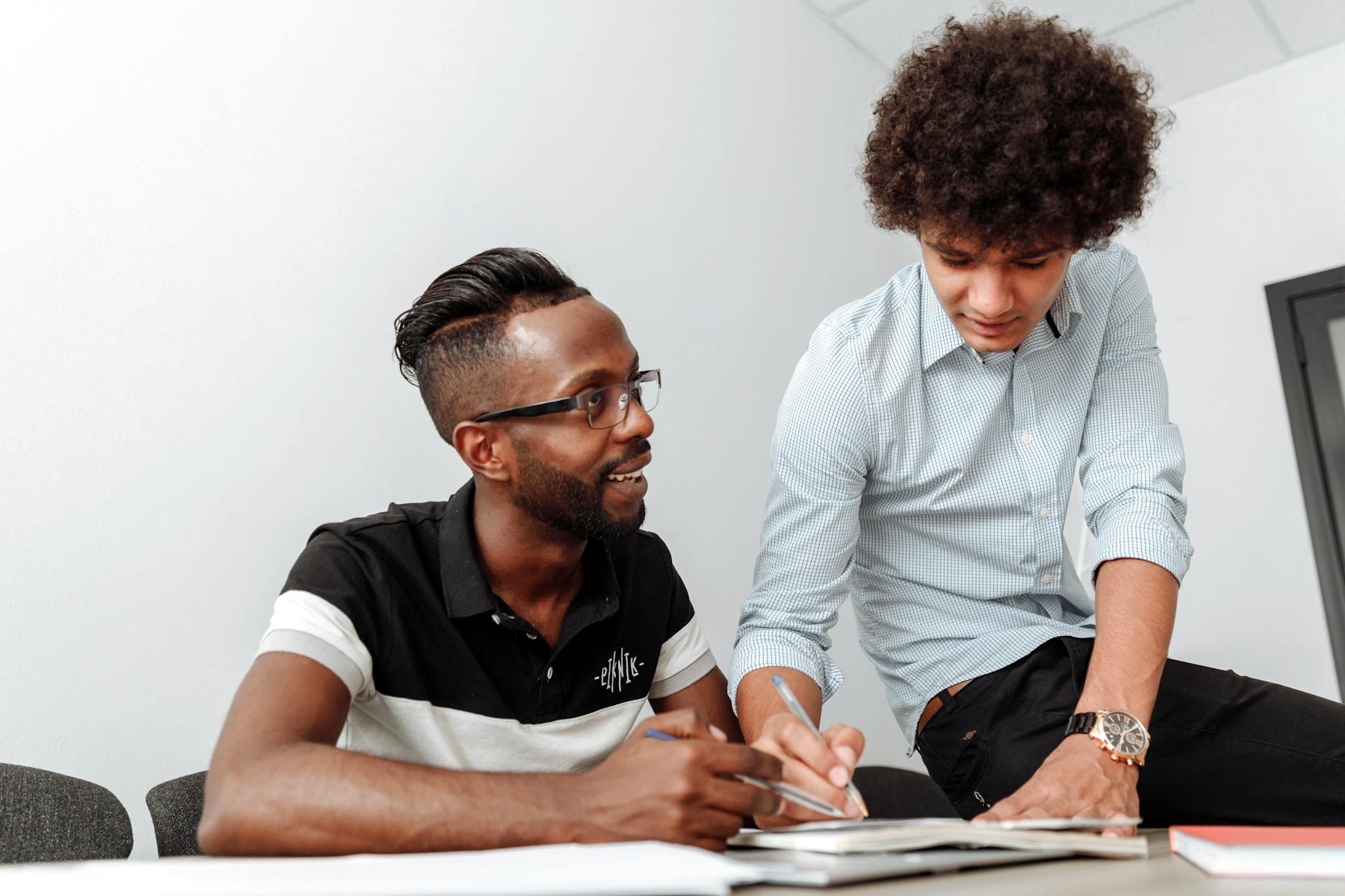 Two Coworkers Collaborating At A Desk Emphasizing